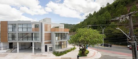Un edificio moderno con diversi piani, ampie finestre e un rivestimento in vetro e legno.