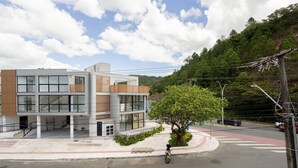 Un bâtiment moderne à plusieurs étages, doté de grandes fenêtres et d’une façade combinant des panneaux de verre et de bois.