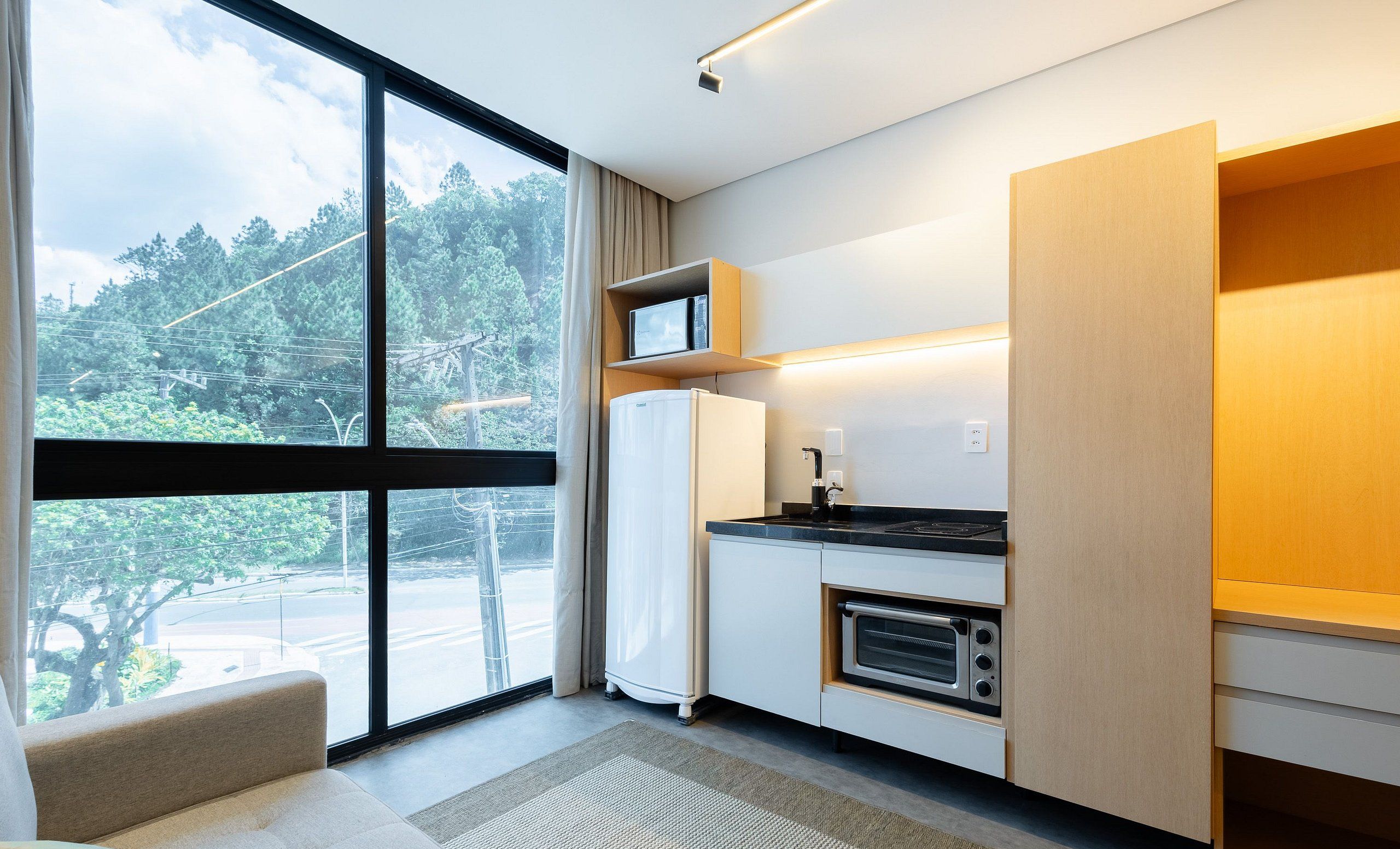 A modern kitchen with a built-in oven, a microwave, and a coffee machine.