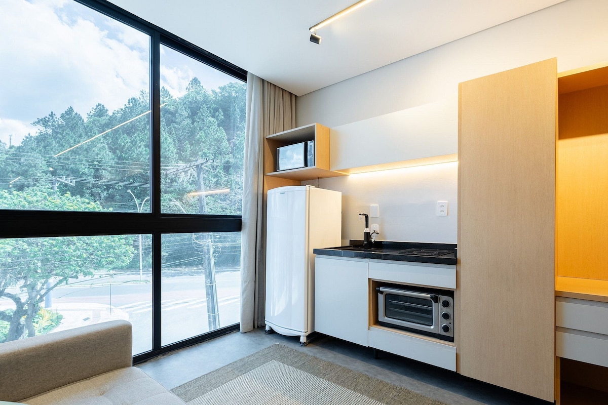 Una cocina moderna con horno integrado, microondas y cafetera.