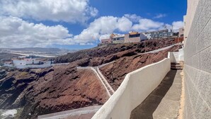 A hillside with a paved path leading to buildings with modern architecture. - PentHouse Loft - Terrace & Natural Pool (Gáldar)
