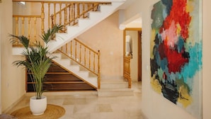 A staircase with wooden balusters and a potted plant at the base.