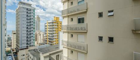 A multi-story residential building with balconies and a clear sky.