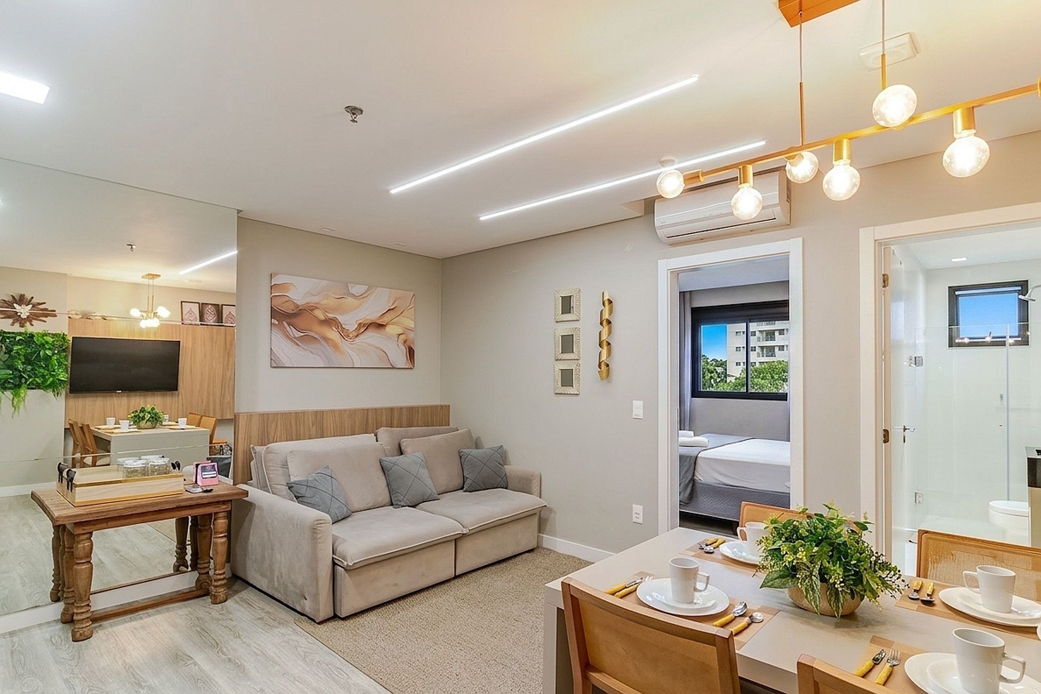 A modern living room with a sofa, dining table, and a TV.