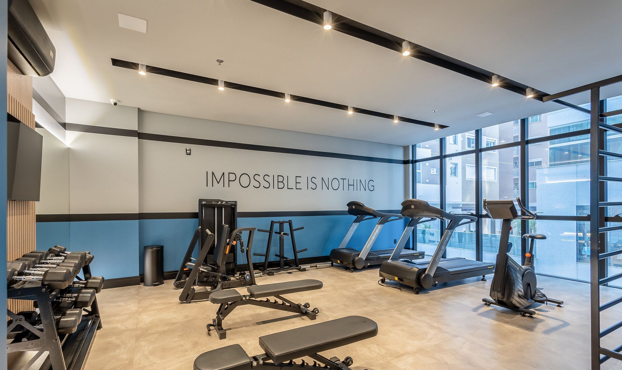 A modern gym with treadmills, weight machines, and dumbbells.