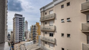 A multi-story residential building with balconies, a visible 'AMARAL' sign, and a clear view of the sea in the background. - IFT - Ed. Infinity Tower Flat 350m From Meia Praia (Itapema)