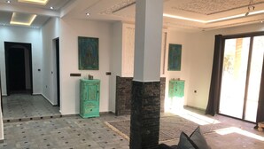 A spacious hallway with patterned flooring, a large pillar, and green cabinets. - HOUSE ROUTE DE L'OURIKA MARRAKECH (Marrakech)
