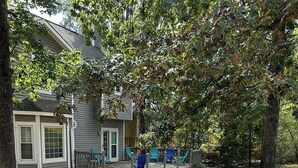 Un jardin avec un foyer en pierre et deux chaises Adirondack bleues.