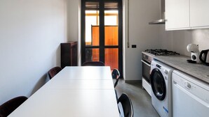A compact kitchen with a washing machine, a stove, and a microwave. - Appartamento Matthias by Wonderful Italy (Bari)