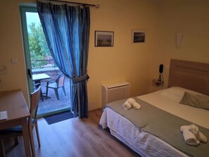 A hotel room with a bed, a desk, a chair, and a view of the outdoors. - L'instant Mont le Viaur (Saint-André-de-Najac)