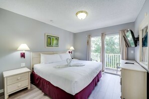 A bedroom with a bed, bedside tables, a dresser, a window with curtains, and a view of greenery outside. - Magical Memories! Splash Pad/Pool Resort! (Kissimmee)