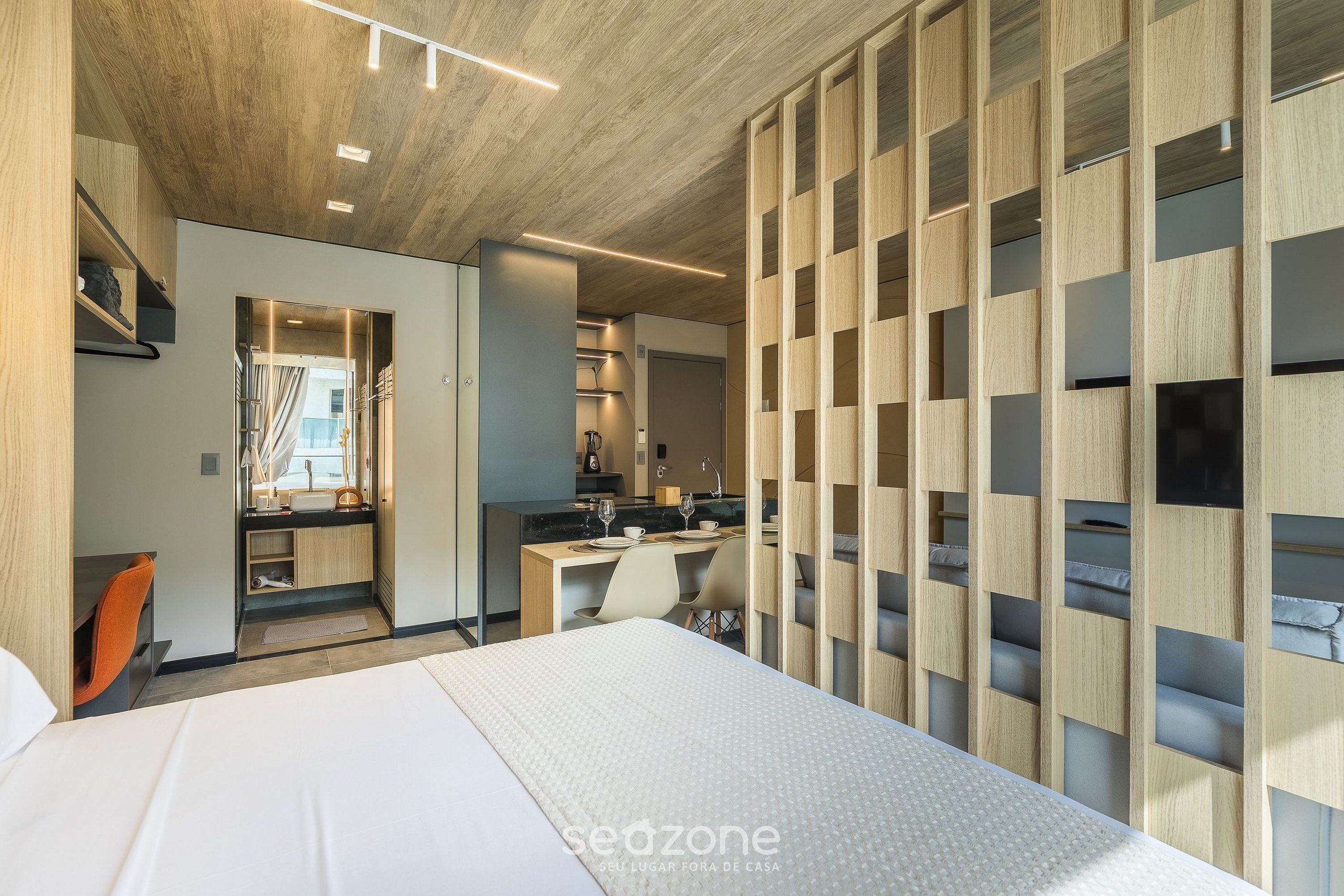 Una habitación de hotel moderna con cama, escritorio y zona de estar.