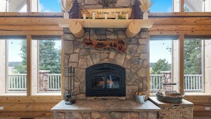 A stone fireplace with a sign above it, a stone bench, and a basket on the right. - Fantastic 5-bedroom Cabin with Wi-Fi in Duck Creek Village  NEW LISTING (Duck Creek Village)