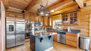 A modern kitchen with wooden cabinets, stainless steel appliances, and a large island. - Fantastic 5-bedroom Cabin with Wi-Fi in Duck Creek Village  NEW LISTING (Duck Creek Village)