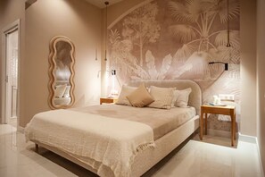Ein Schlafzimmer mit einem großen Bett, einem Spiegel, zwei Nachttischen und einem Wandbild.
