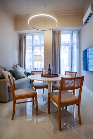 Ein moderner Essbereich mit einem runden Tisch, Holzstühlen und einer Chandelier.