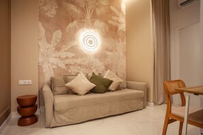 Ein modernes Wohnzimmer mit einer Couch, einem runden Tisch und einer Wandleuchte.