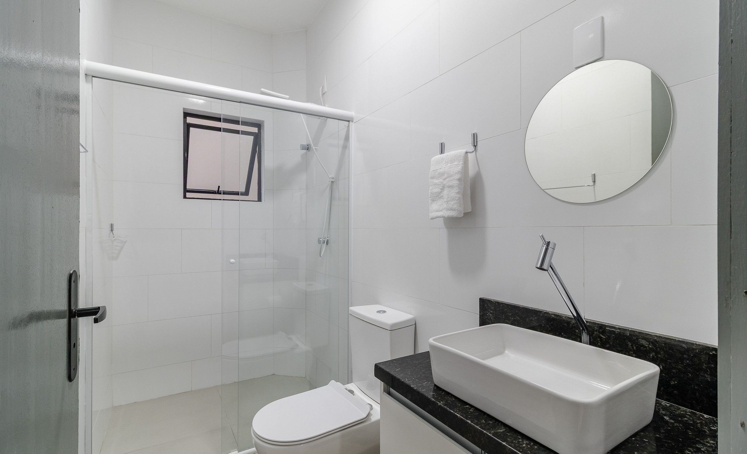Une salle de bain équipée d’une douche, de toilettes, d’un lavabo et d’un miroir.