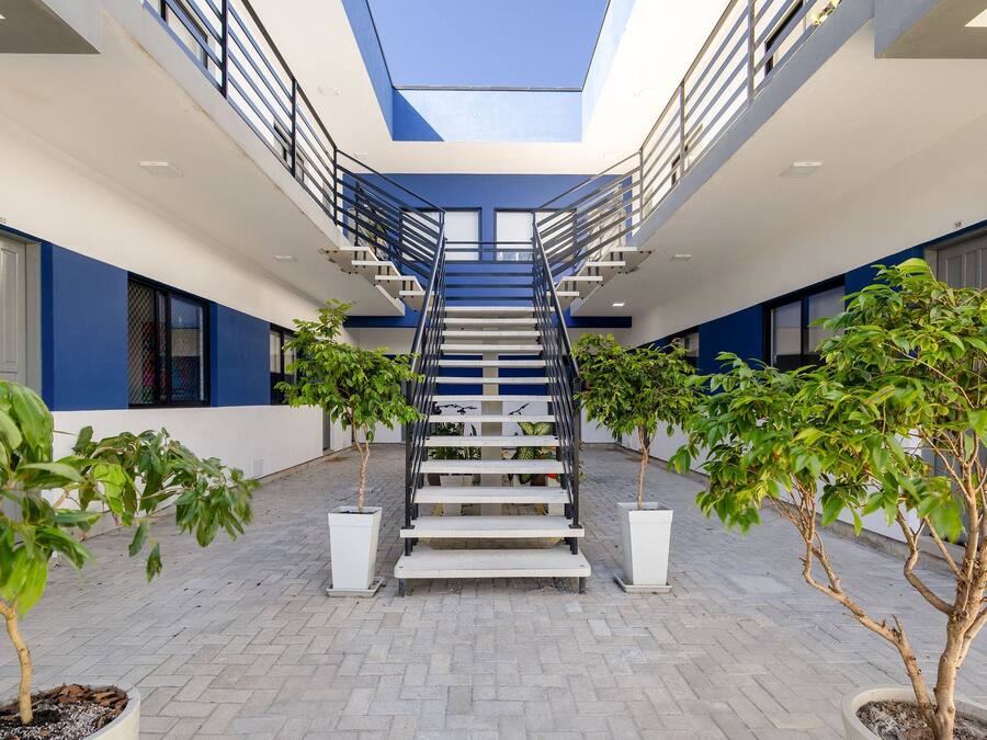 A modern building with a central staircase, potted plants, and a skylight.
