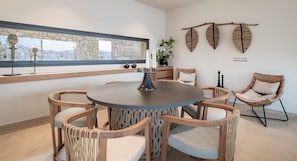 A round table with six chairs, a large mirror, and a wall-mounted plant. - Country House 'Myporos' with Sea View, Wi-Fi and Air Conditioning (Poros)