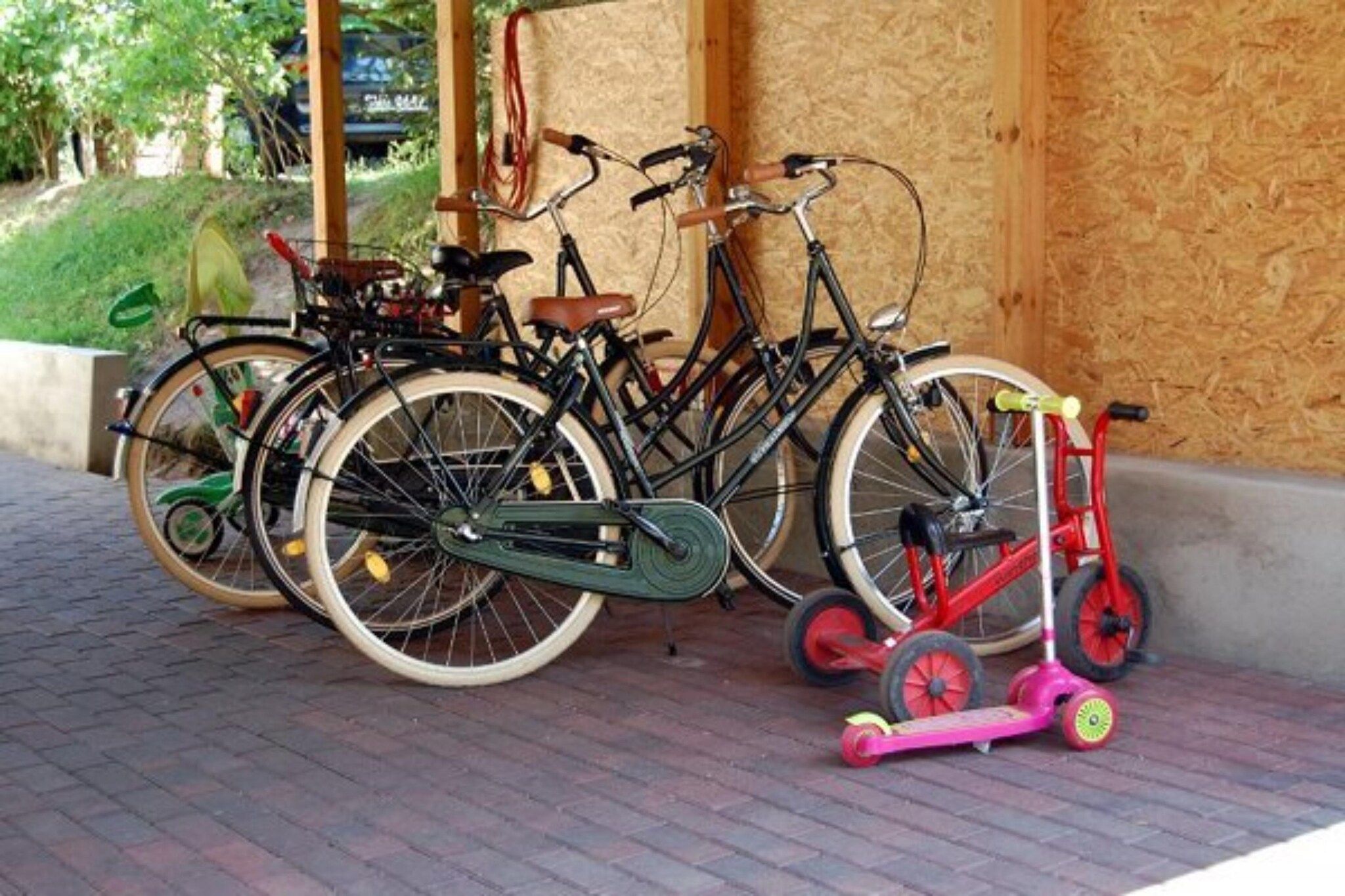 Des vélos et un tricycle sont garés sur une surface pavée.
