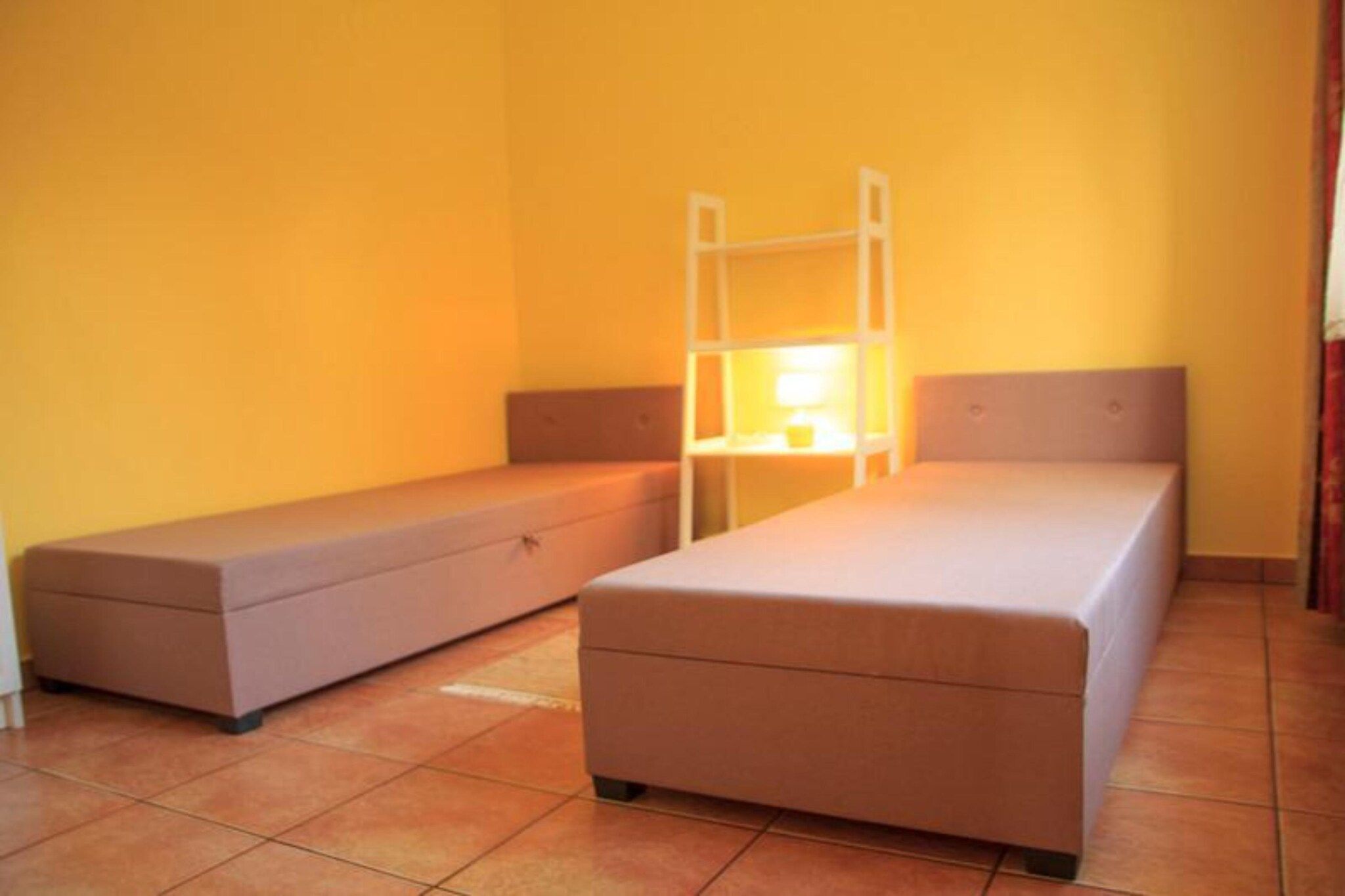 A small, single-room accommodation with a bunk bed and a single bed.
