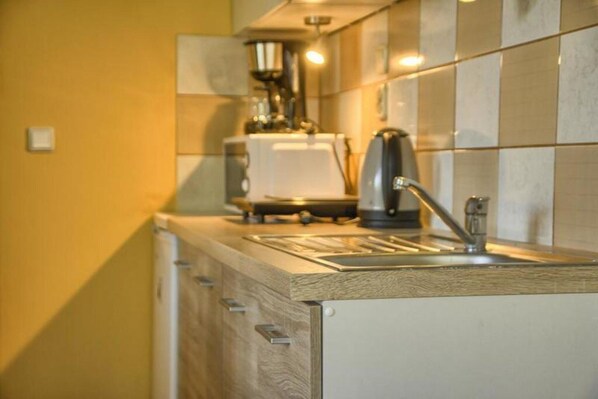 A kitchen with a sink, a toaster, and a kettle.