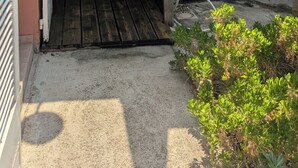 A wooden gate leading to a covered outdoor area with a shower. - Quiet family home with garden and small pool. Close to beach and shops. (Le Grau-du-Roi)