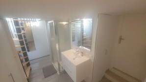 A bathroom with a white sink, mirror, and shower. - Quiet family home with garden and small pool. Close to beach and shops. (Le Grau-du-Roi)