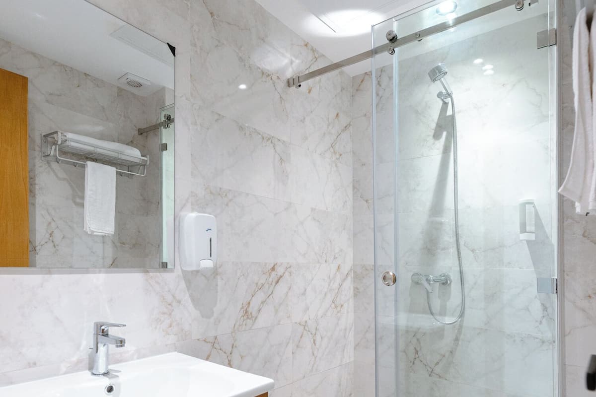 Une salle de bain moderne avec un meuble-lavabo en marbre, une cabine de douche en verre et des toilettes.