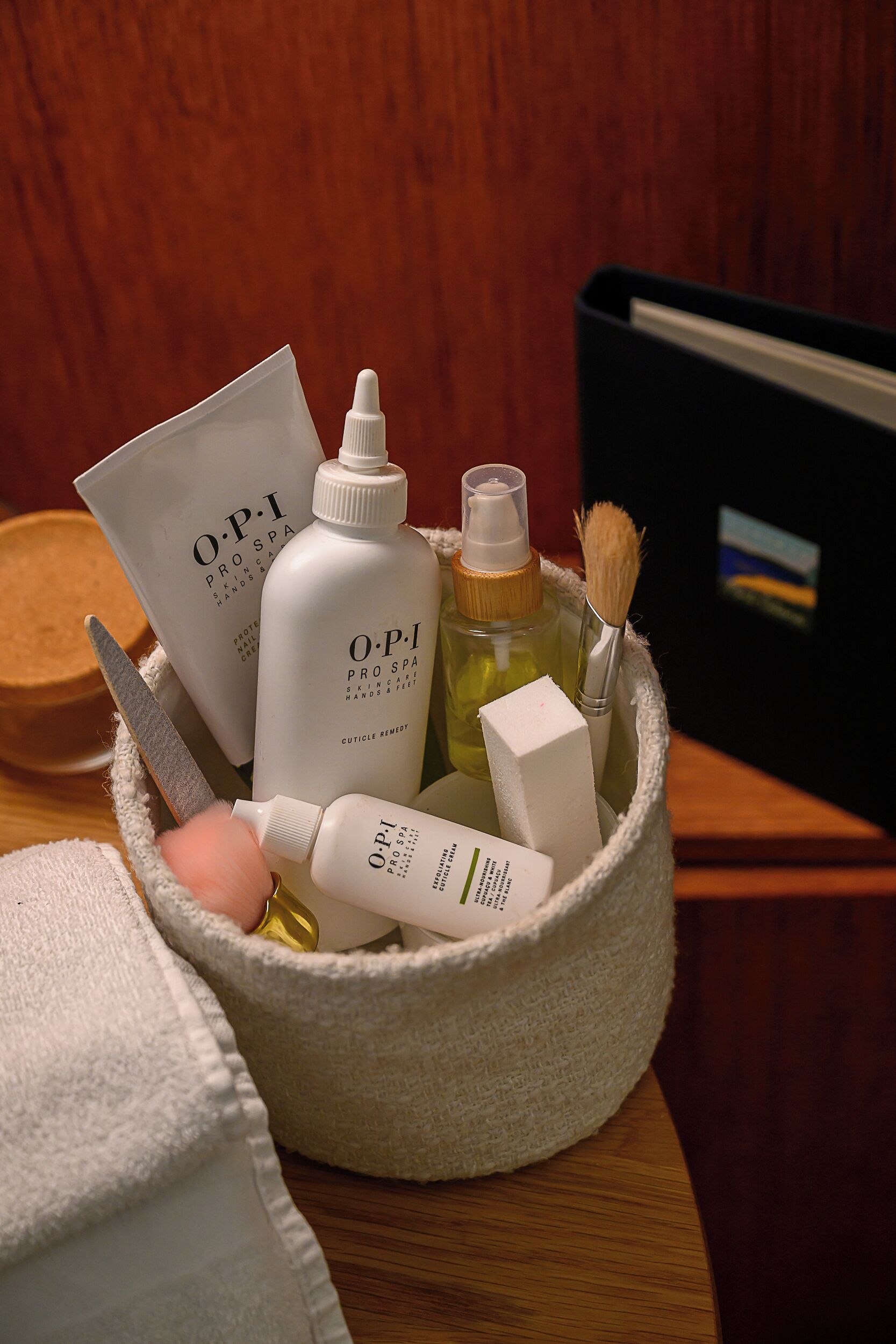 A basket containing various skincare products, including bottles and a brush.