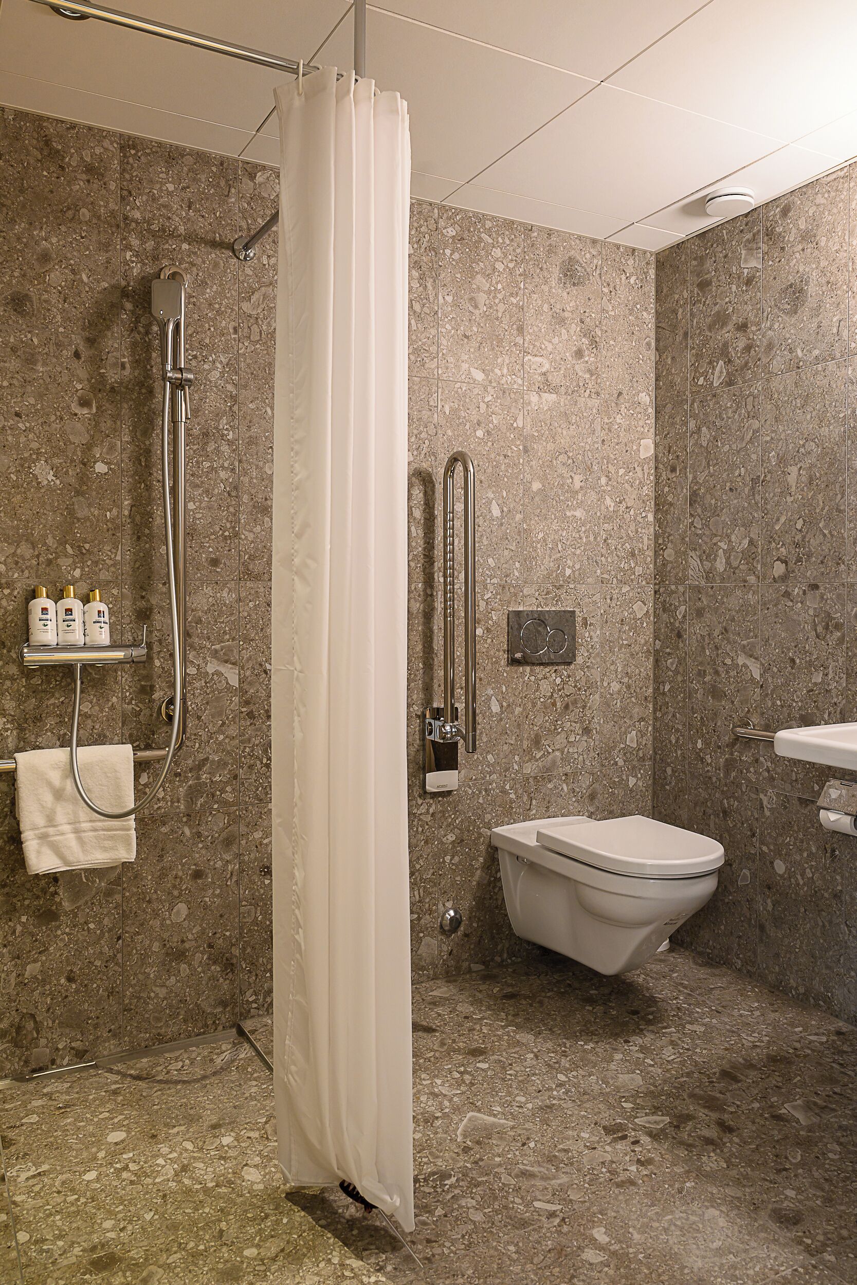 Un baño con ducha, inodoro y lavabo.