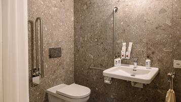 Un baño con inodoro, lavamanos y ducha.