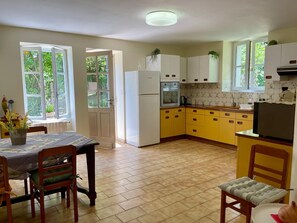Une cuisine équipée d’une table à manger, de chaises, d’un réfrigérateur, d’un four et de placards.