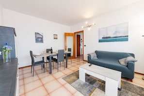 En moderne stue med sofa, spisebord, stole og sofabord.
