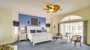 A bedroom with a large bed, two bedside tables, a chair, a desk, and a large window. - Poolside Bliss & Lake Fun: Florida Getaway! (Fort Ogden)