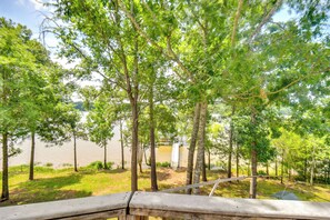 A view of a lakeside area with trees and a wooden deck.