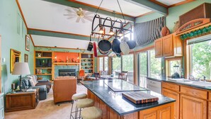 A kitchen with a central island, wooden cabinets, and a large window. - Boat Dock Access: Clarks Hill Lake Hideaway! (Elberton)