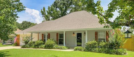 A single-story house with a sloped roof, a front porch, and a well-maintained lawn.