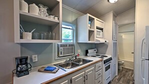 A compact kitchen with a built-in oven, a coffee maker, and a sink. - Resort Cabin 1 Mi to Middle Bass Island State Park (Put-in-Bay)