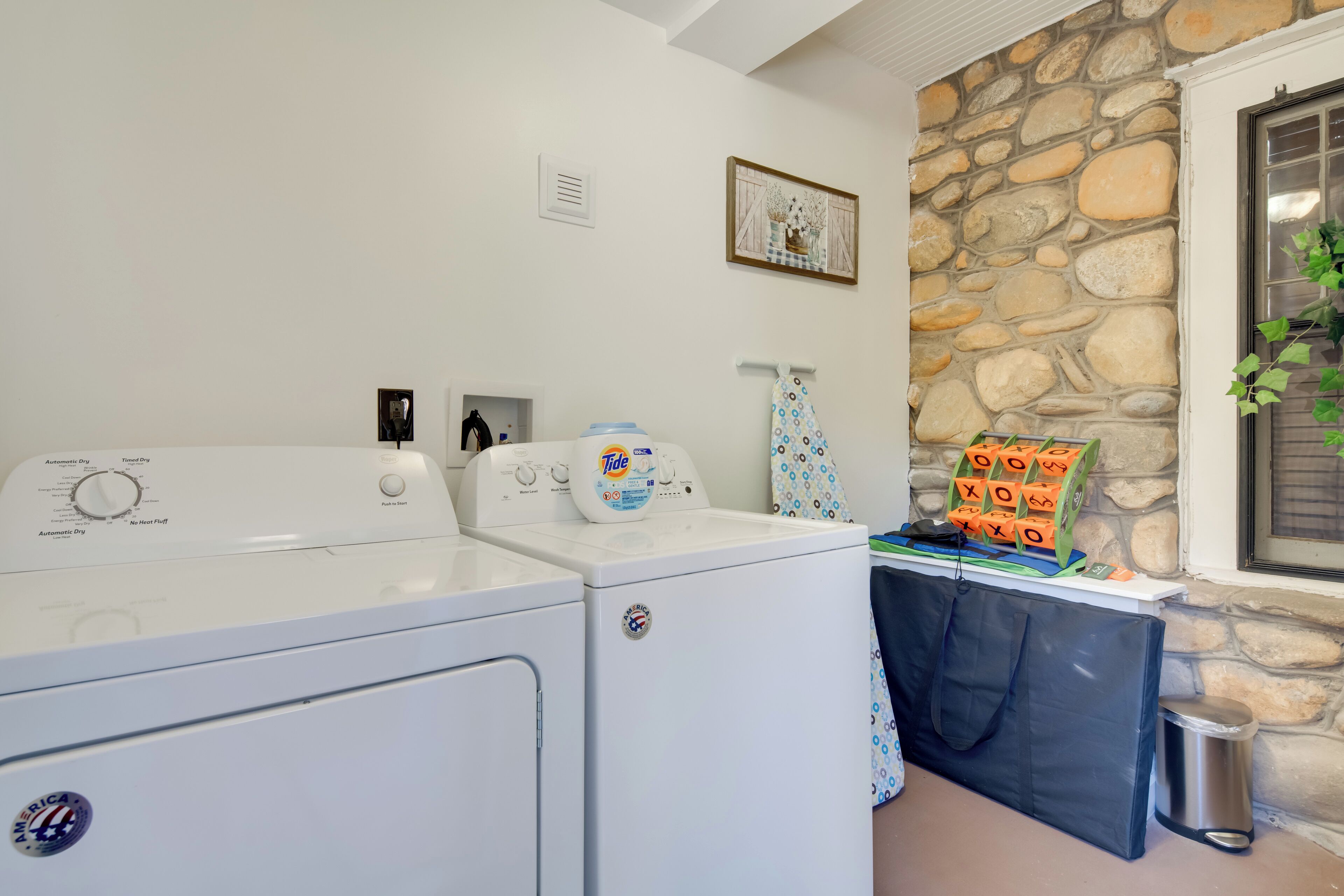 A laundry area with a washing machine, dryer, and stacked laundry baskets.