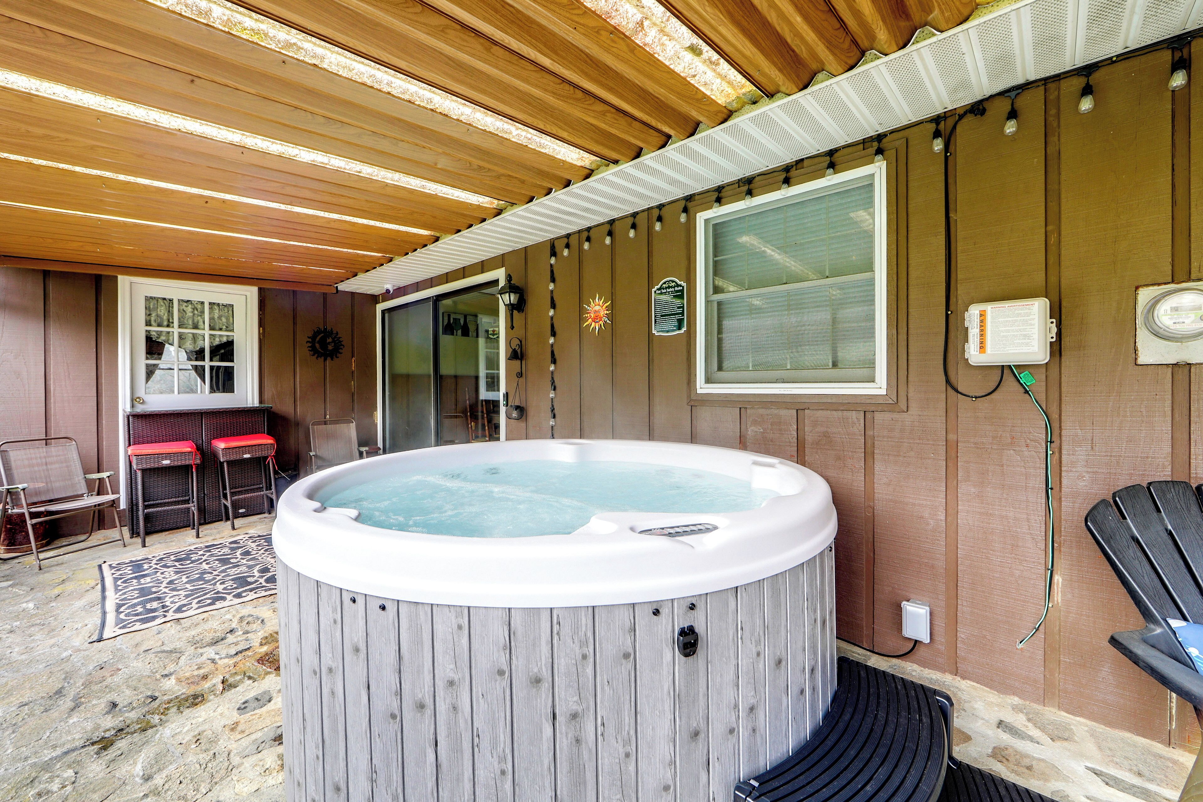 Ein Zimmer mit Holzboden, einer Badewanne, einem Fenster und einer Tür zu einem anderen Raum.