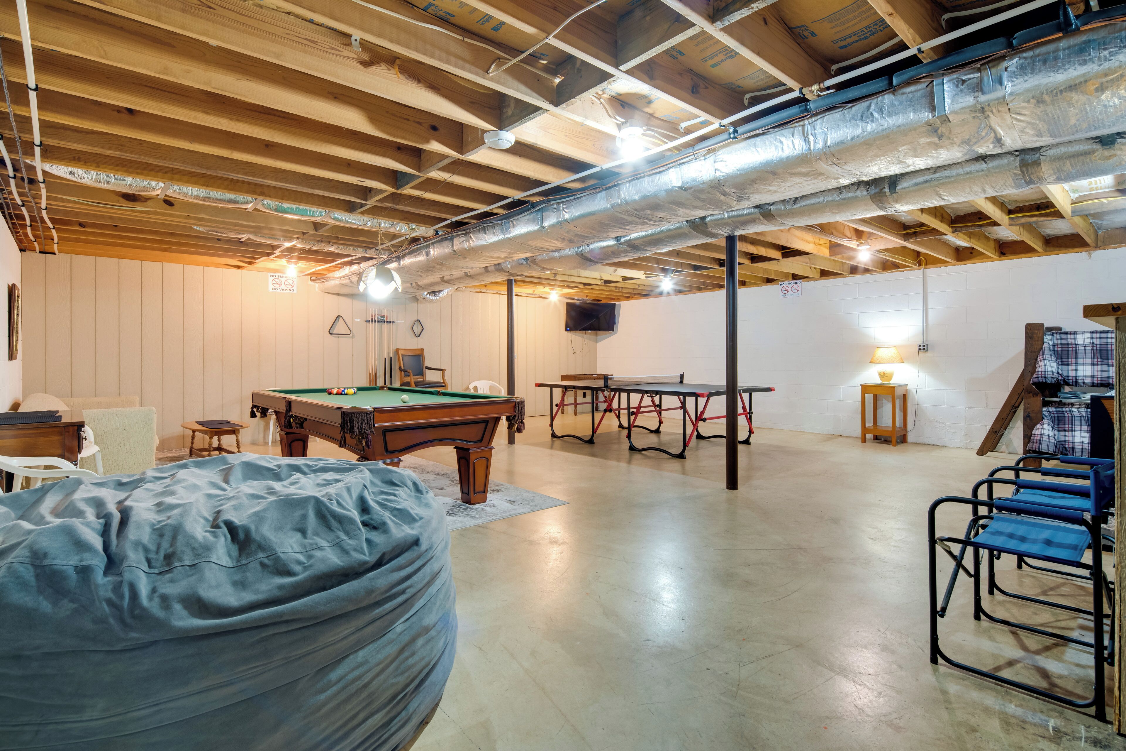 A spacious room with a pool table, a billiards table, and a ping pong table.
