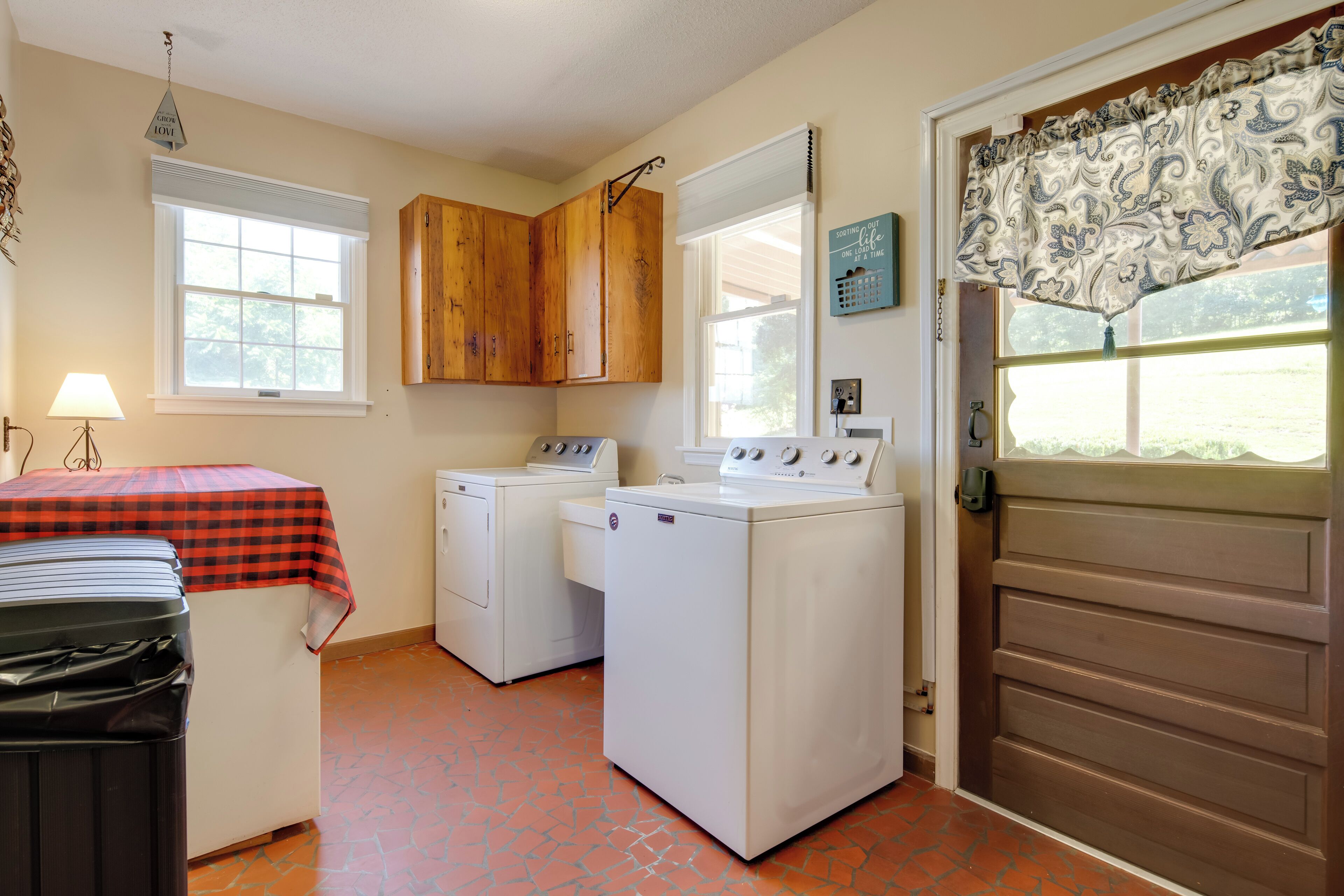 A laundry room with a washing machine, dryer, and stacked laundry baskets.