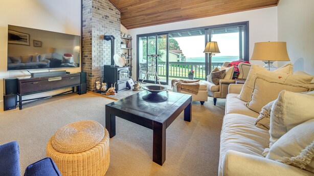 Una sala de estar con chimenea, televisor, sofá y mesa de centro.