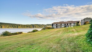 Un edificio residencial con vistas a un lago y un bosque.