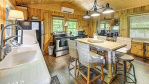 A wooden cabin interior with a kitchen, dining area, and a large sink. - Hike, Fish & Explore: Family Retreat in Highlands (Highlands)