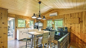 A wooden cabin interior with a kitchen, dining area, and a staircase. - Hike, Fish & Explore: Family Retreat in Highlands (Highlands)