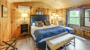 A wooden-paneled bedroom with a large bed, a ceiling fan, and a window with shutters. - Hike, Fish & Explore: Family Retreat in Highlands (Highlands)