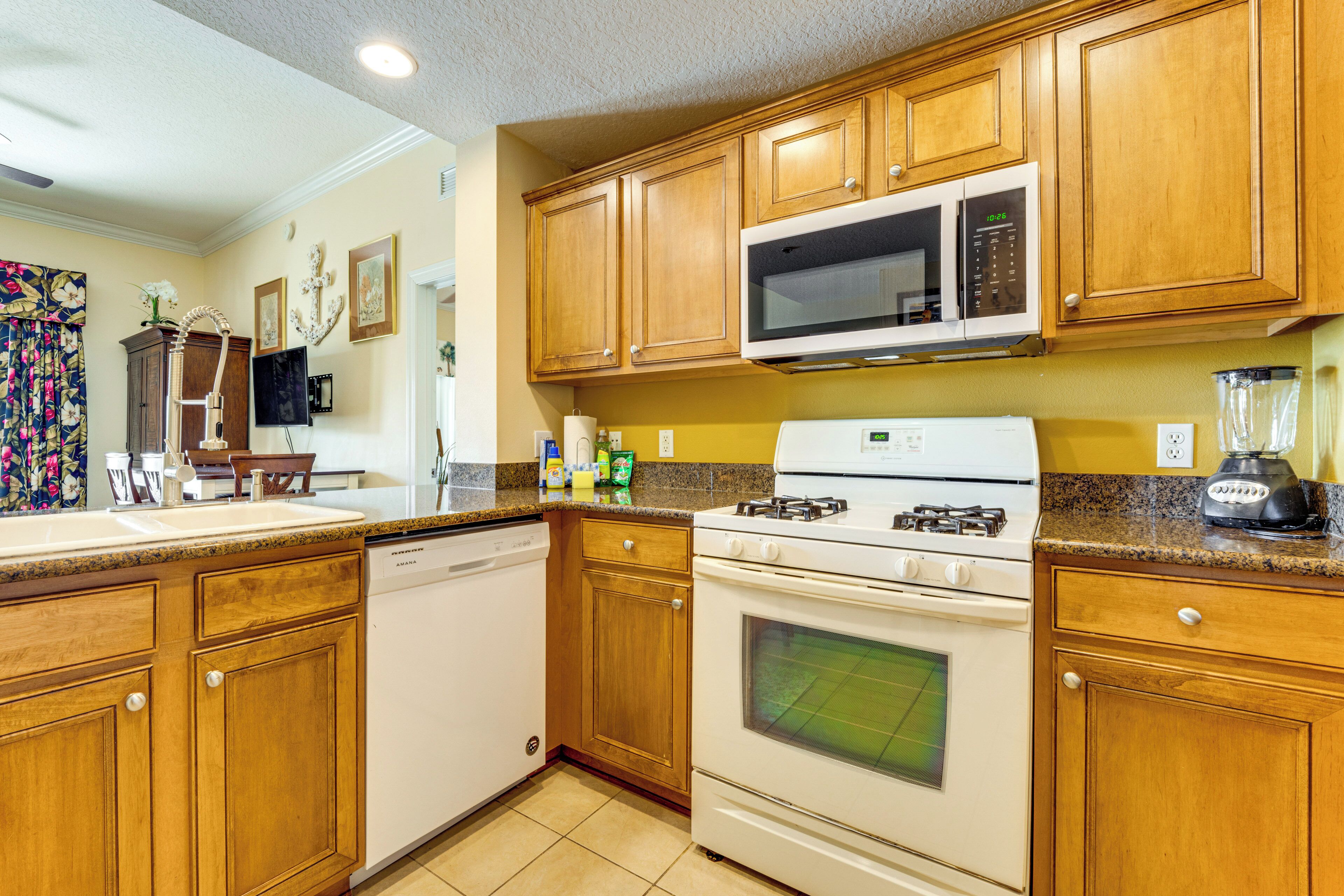 A kitchen with wooden cabinets, a microwave, a stove, and a dishwasher.